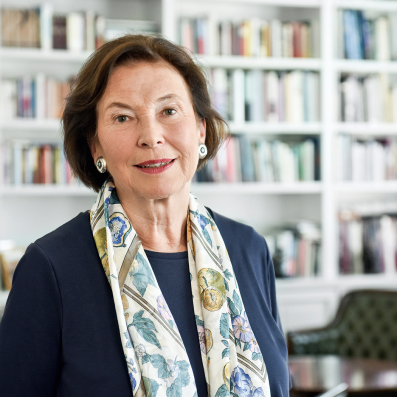 Eva Luise Köhler, © Andrea Katheder Porträt von Eva Luise Köhler, der Schirmherrin der ACHSE e. V., mit kinnlangem, braunem Haar. Sie trägt ein dunkelblaues Oberteil und einen farbenfrohen Schal mit Blumenmuster. Sie steht in einem Raum vor einem Bücherregal und lächelt leicht in die Kamera.