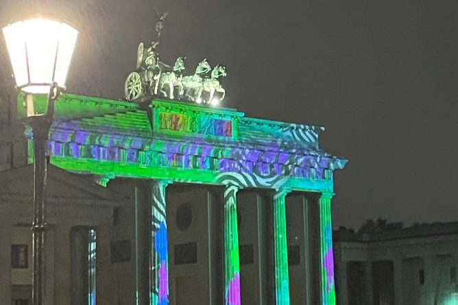 Zebraprojektion im Rahmen der 2. Sebracon Brandenburger Tor bei Nacht mit bunter Zebraprojektion auf den Säulen und dem Dach